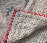 KalaIndia Flamingo Snow Baby Quilt (White) – baby quilts India (styled in a nursery/crib)